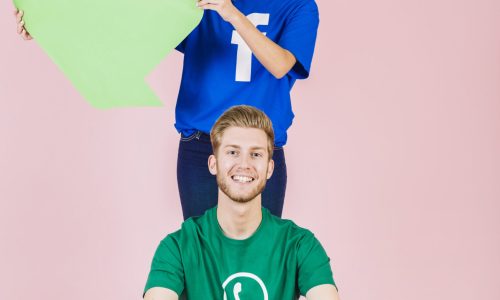 happy-man-sitting-front-woman-holding-empty-green-speech-bubble